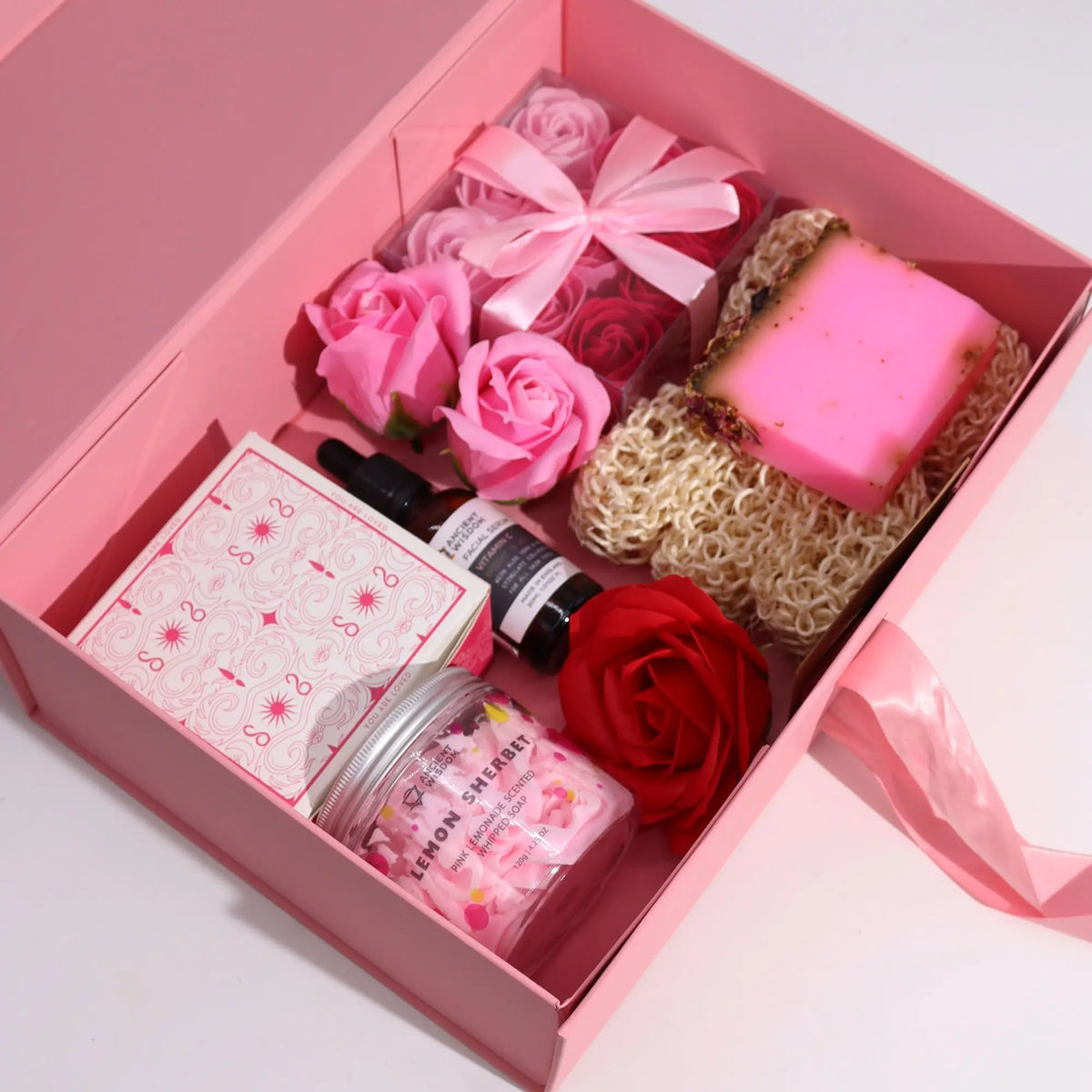 Caja regalo rosa con lazo, conteniendo set de belleza Ancient Wisdom: flores de jabón, jabón artesanal y cosméticos.