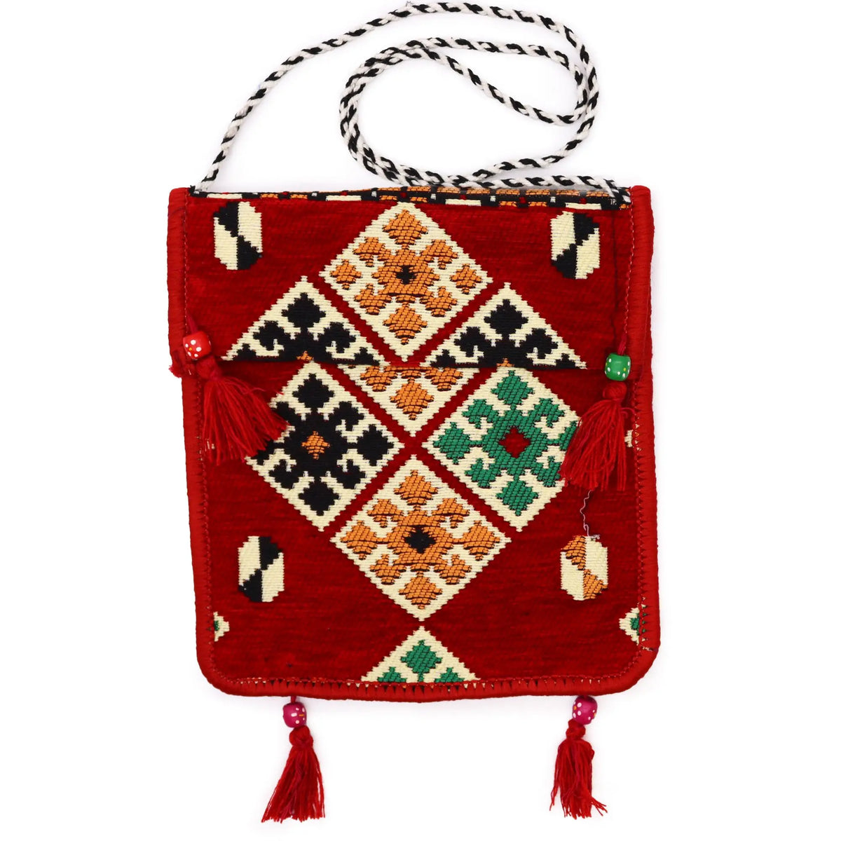 Bolso bandolera de kilim rojo con motivos geométricos, borlas decorativas y asa trenzada en blanco y negro.