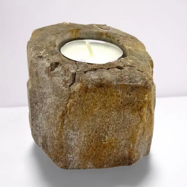 Portavelas bajo de madera petrificada con textura rugosa y tonos tierra que contiene una vela blanca tipo tea light