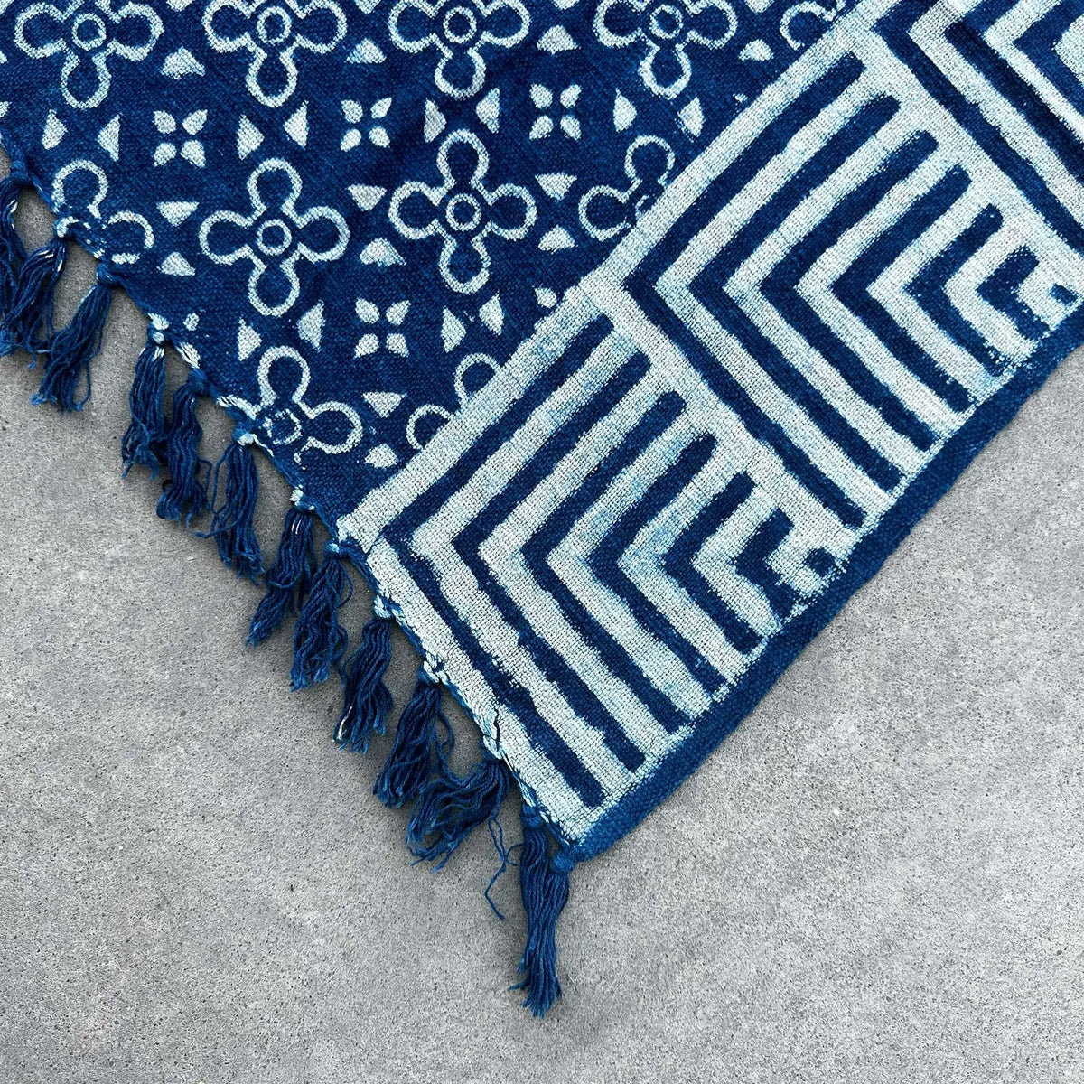 Alfombra azul marino con patrón geométrico y flecos, ideal para dar un toque moderno a cualquier espacio.