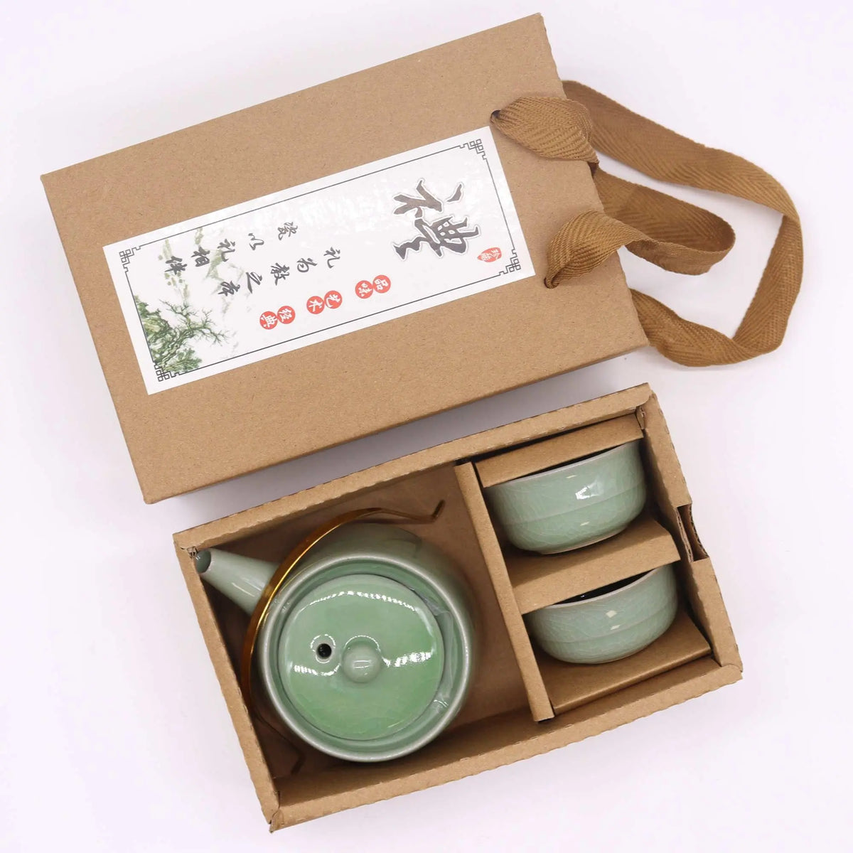 Set de tetera verde de cerámica con dos tazas y asa metálica, presentado en una caja de regalo artesanal de cartón.