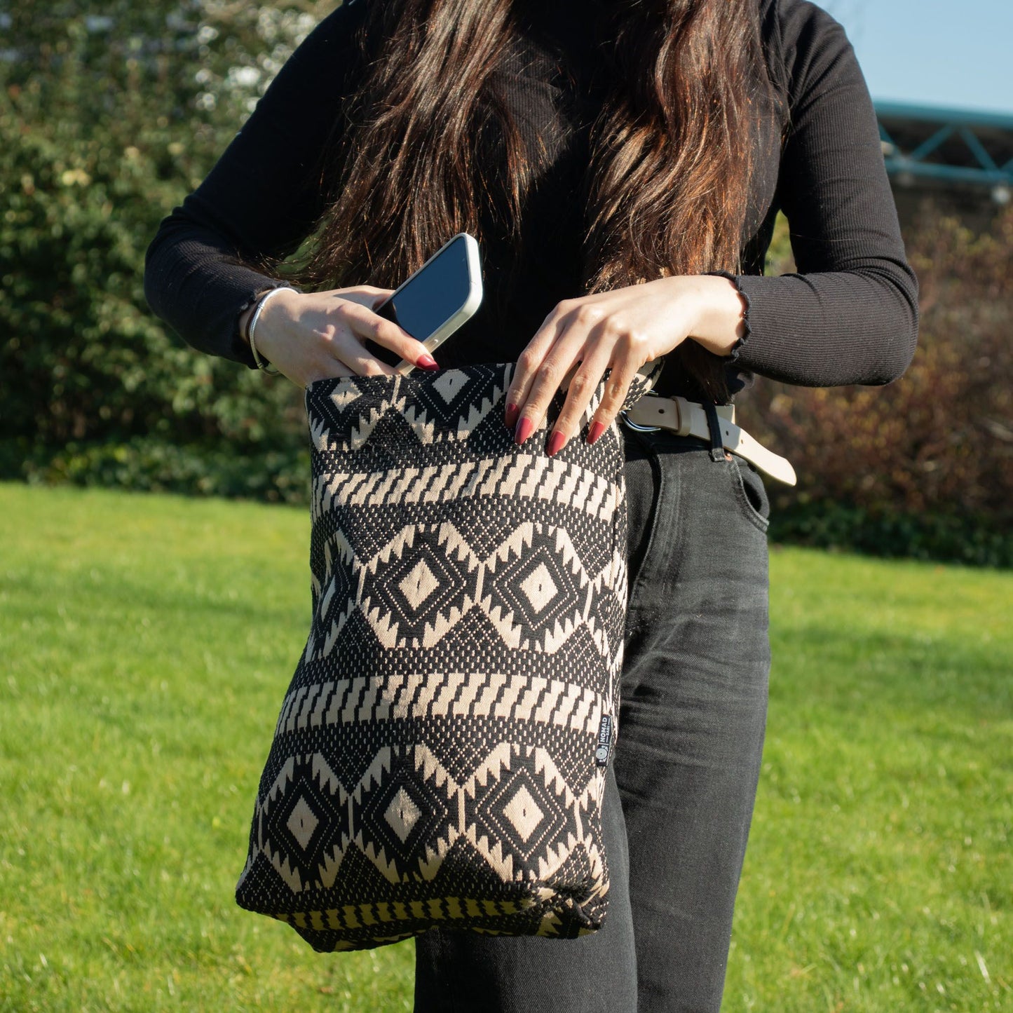 Bolso de tela negro y beige con diseño geométrico, ideal para un estilo casual y moderno.