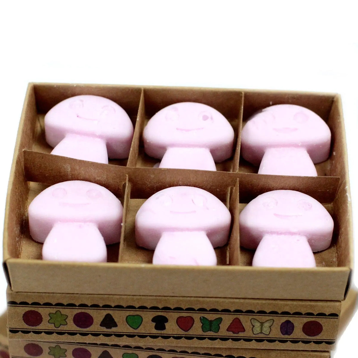 Caja de cartón con 6 ceras de soja rosas en forma de setas con caritas felices, estilo artesanal y decorativo.