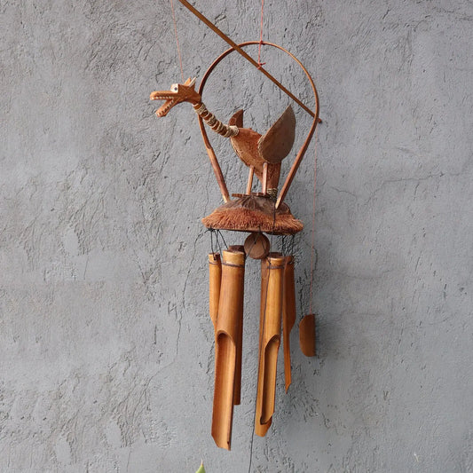 Campanilla de viento de bambú y coco con figura artesanal de dragón en tonos naturales sobre fondo gris texturizado