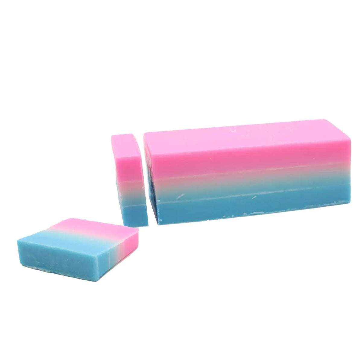 Barra de jabón artesanal rectangular en degradado rosa y azul, con dos trozos cortados sobre fondo blanco.