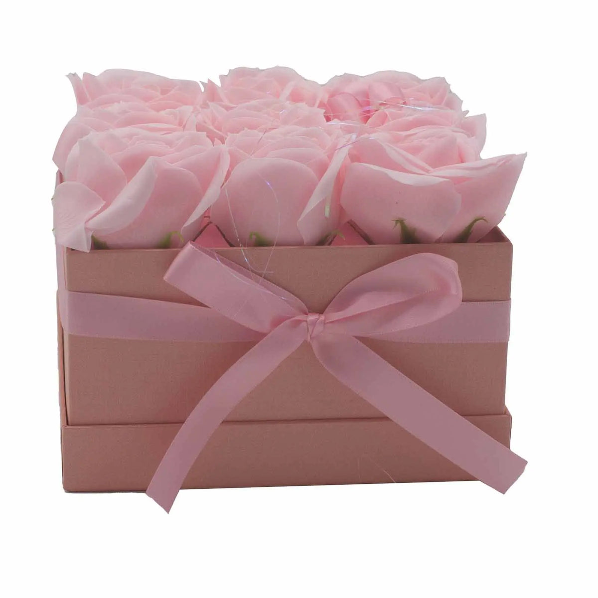 Caja cuadrada rosa con lazo, conteniendo 9 rosas de jabón en tonos rosa suave. Presentación de regalo elegante.