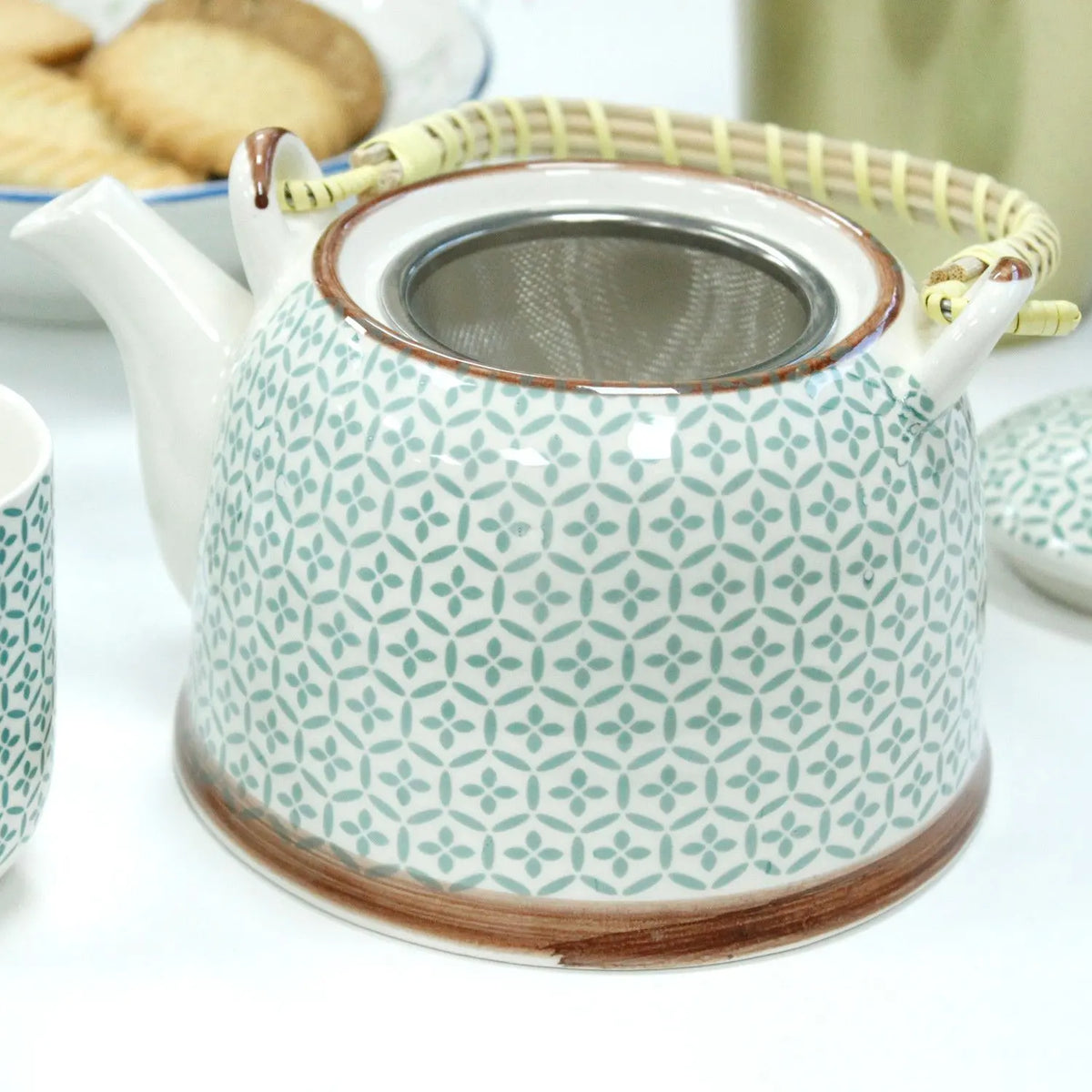 Tetera de cerámica con diseño de mosaico verde y blanco, colador de metal y asa de estilo rústico tejida