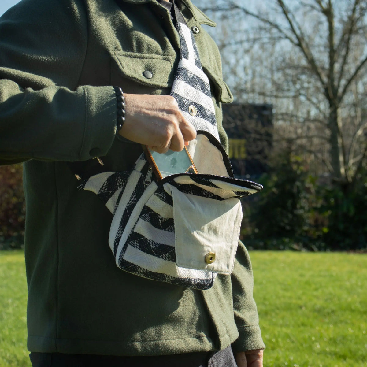 Bolso de mano negro y blanco de tela con tirantes, estilo casual, ideal para uso diario.