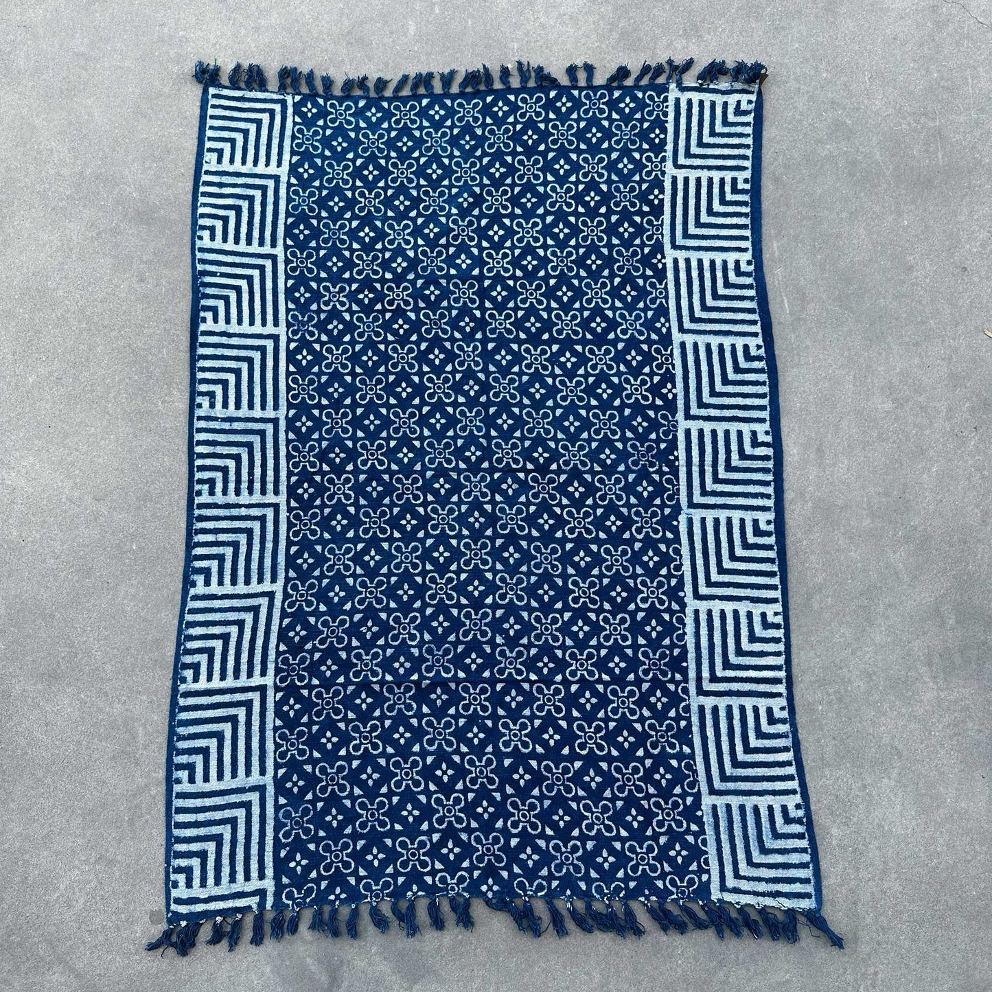 Manta azul marino con estampado blanco, material suave y diseño bohemio, con flecos en los bordes.