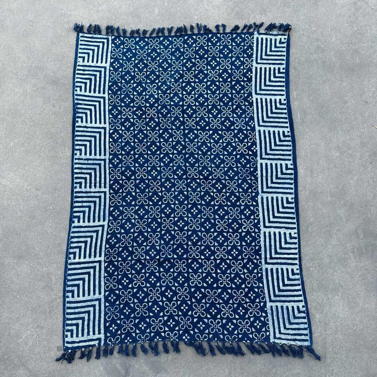 Manta azul marino con estampado blanco, material suave y diseño bohemio, con flecos en los bordes.
