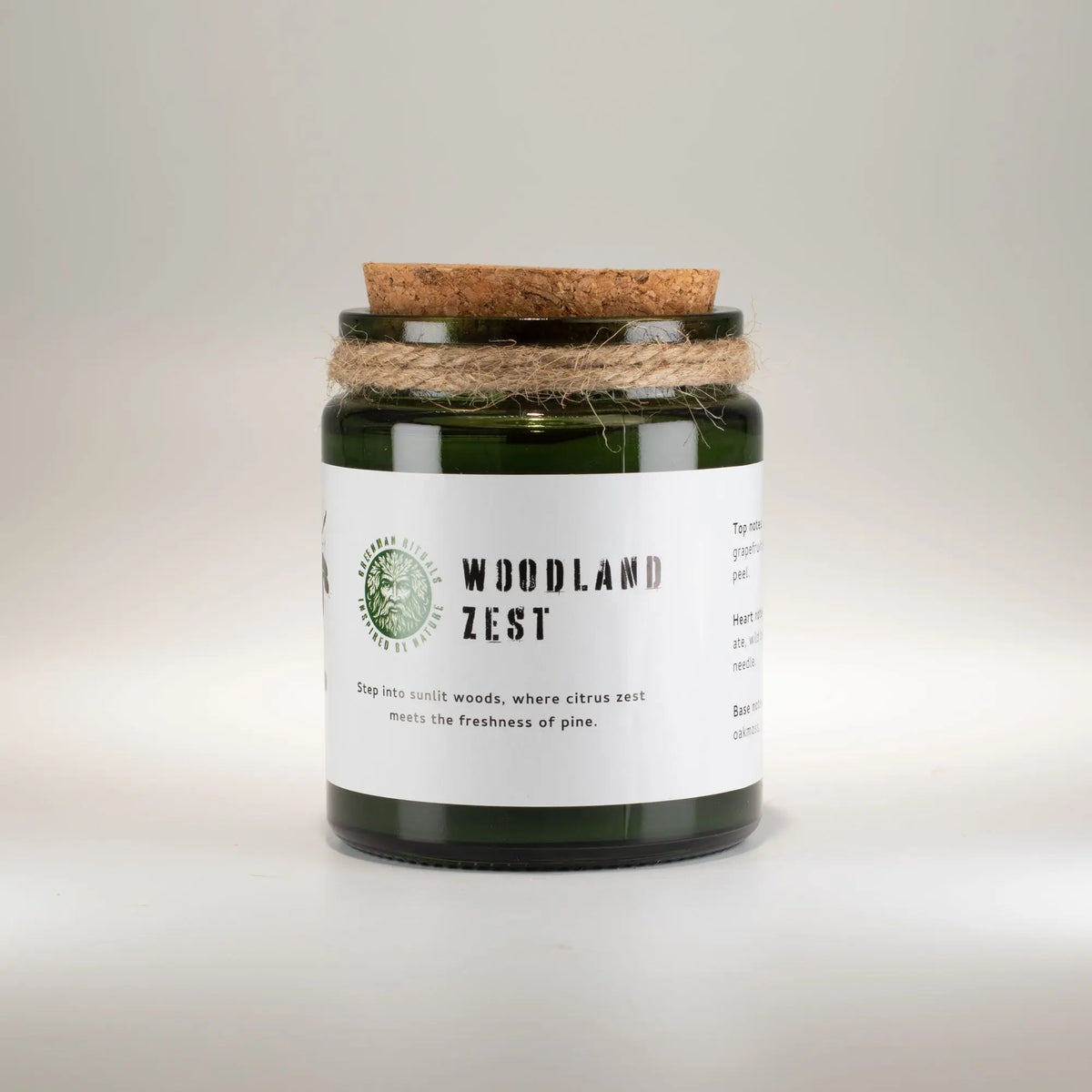 Vela verde "Woodland Zest" en recipiente de vidrio, con tapa de corcho y cuerda decorativa, aroma a cítricos y pino.