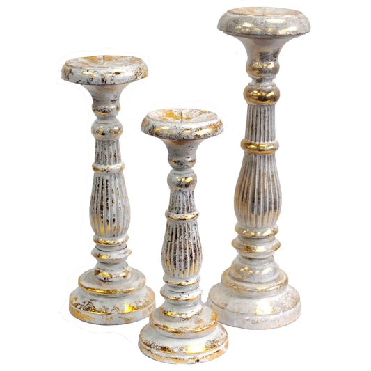 Tres candelabros de madera vintage con acabado desgastado en blanco y toques dorados, de estilo elegante y clásico.