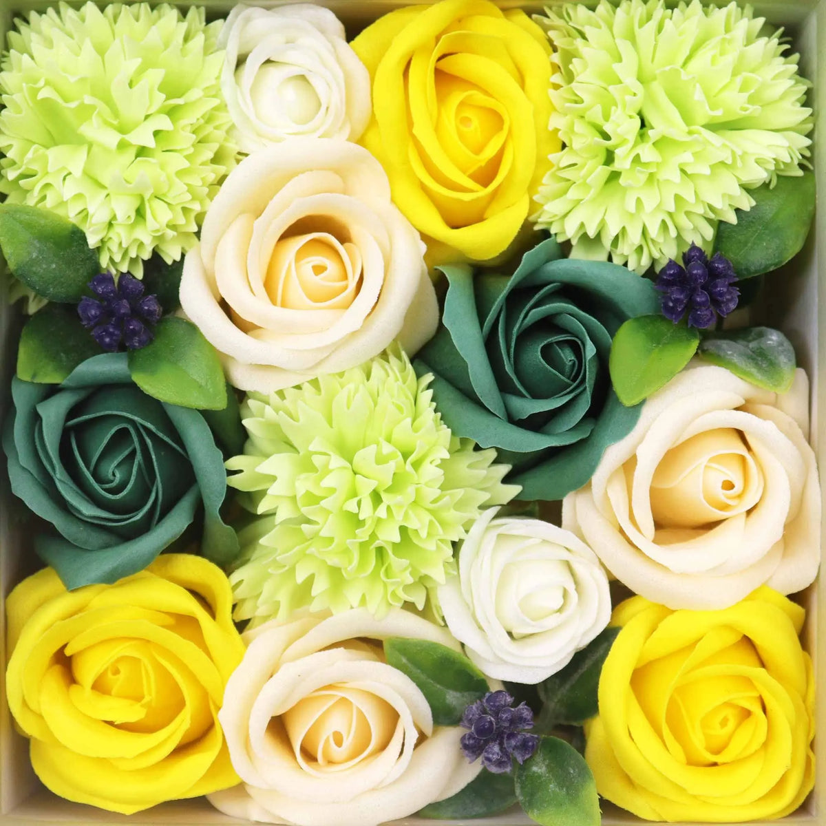 Caja cuadrada con flores de jabón en tonos amarillo, crema y verde, con pequeños detalles de frutos morados.