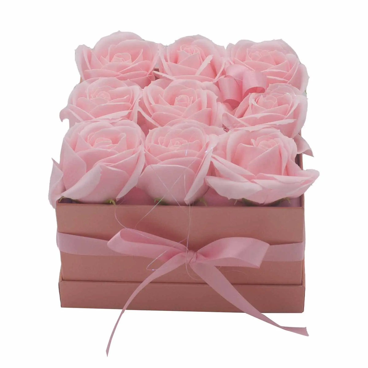 Caja cuadrada rosa con nueve rosas de jabón rosadas, decorada con un lazo a juego. Estilo elegante y artesanal.