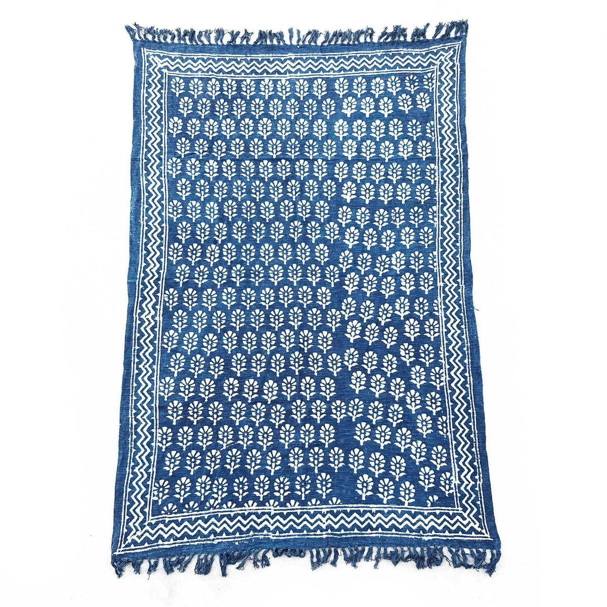 Alfombra azul índigo de algodón con estampado blanco de árboles y fringes, estilo artesanal.
