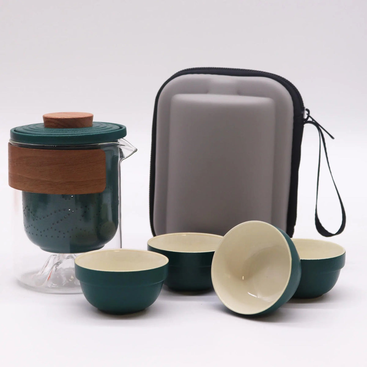 Set de té portátil: tetera de vidrio con filtro verde y madera, cuatro tazas a juego y estuche rígido protector gris.