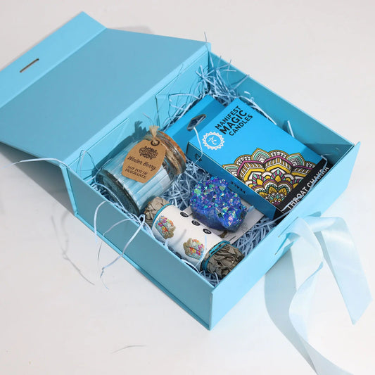 Caja de regalo azul celeste plegable con lazo, rellena de virutas de papel y diversos artículos de regalo en su interior.