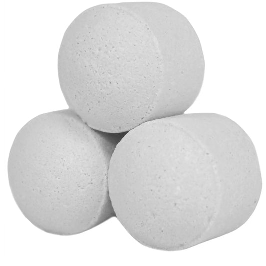Tres mini bombas de baño blancas de textura porosa y forma cilíndrica apiladas sobre fondo blanco