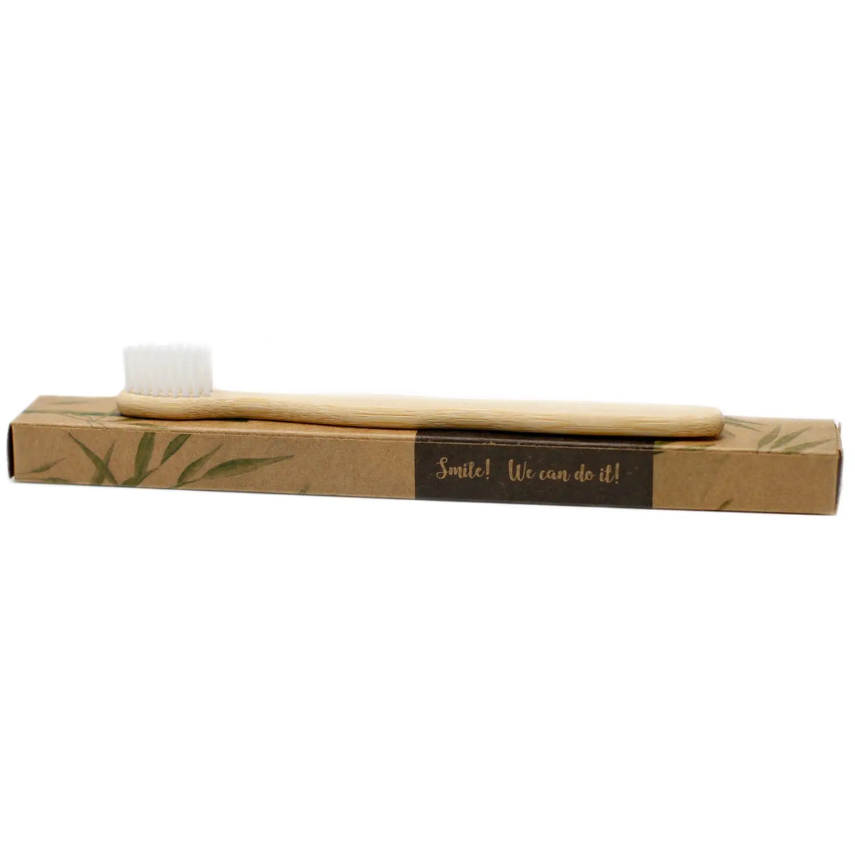 Cepillo de dientes de bambú con cerdas blancas sobre caja de cartón reciclado con diseño natural y fondo blanco