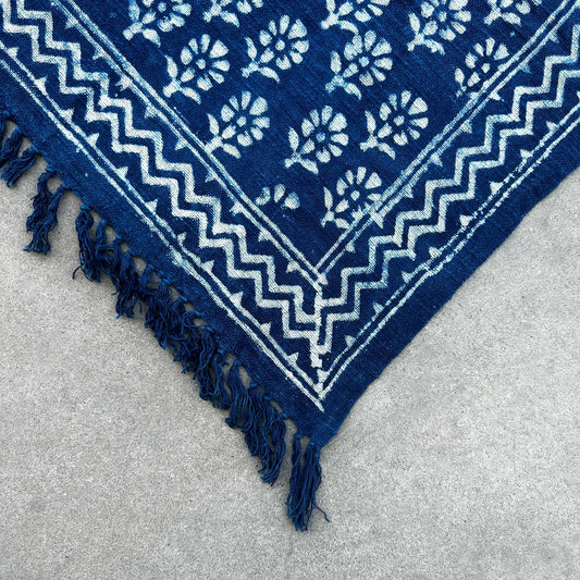 Alfombra azul marino de algodón con diseño floral y flecos, estilo bohemio. Ideal para decoración interior.