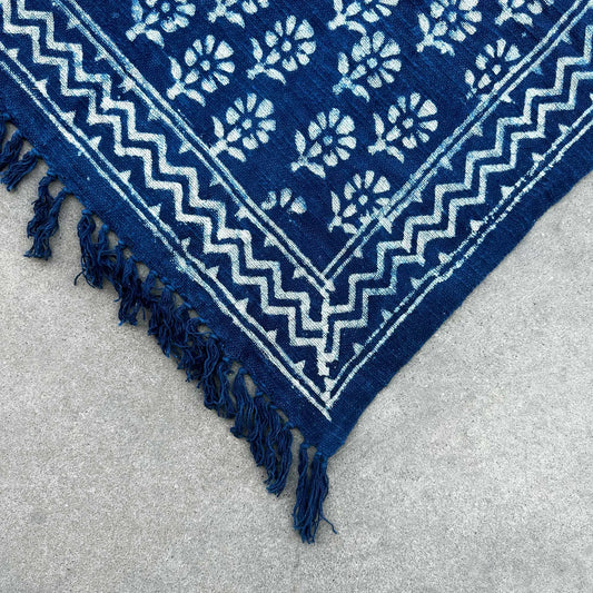Alfombra azul marino de algodón con diseño floral y flecos, estilo bohemio. Ideal para decoración interior.