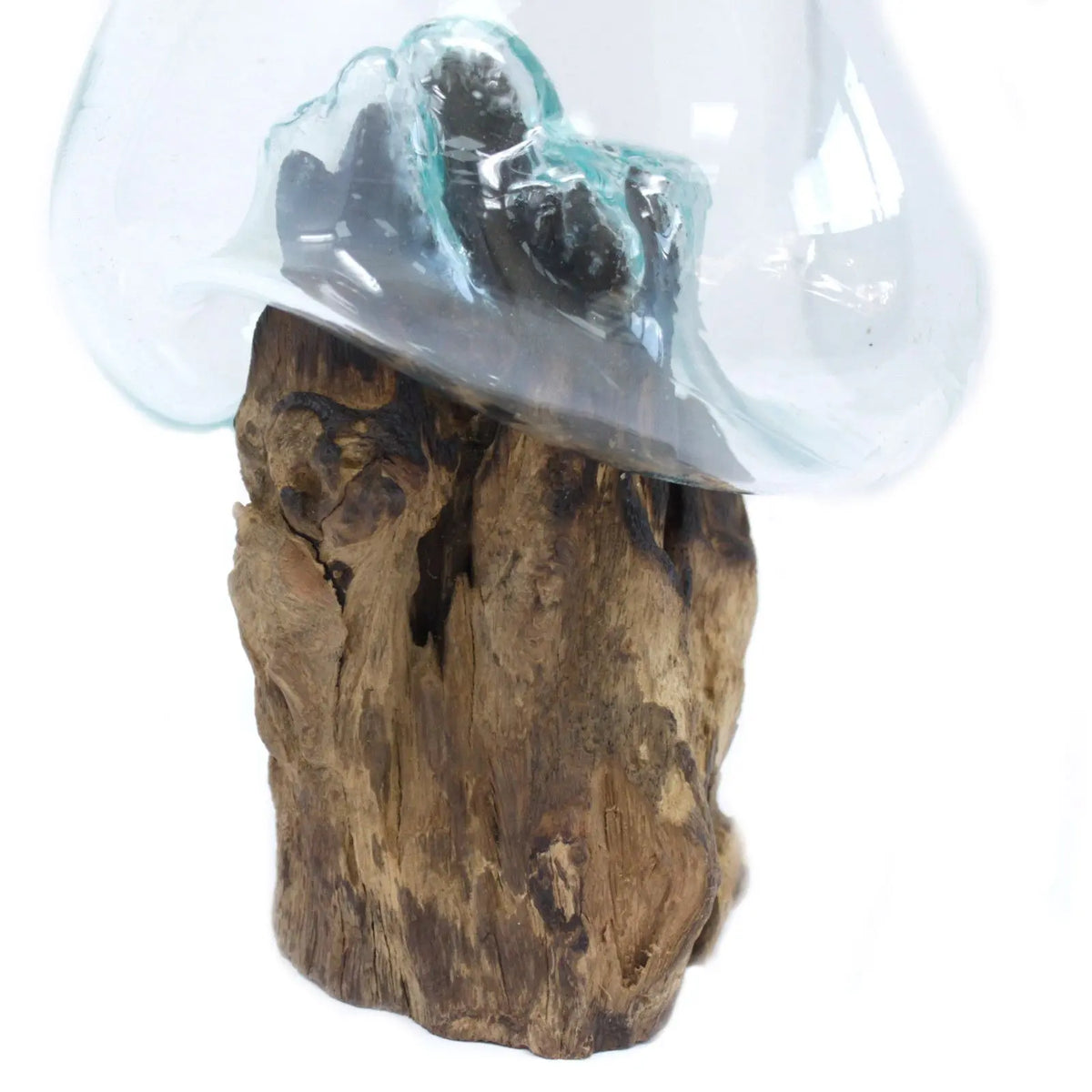 Tazón de vidrio soplado transparente fundido sobre una base de madera natural con textura rugosa, estilo artesanal.