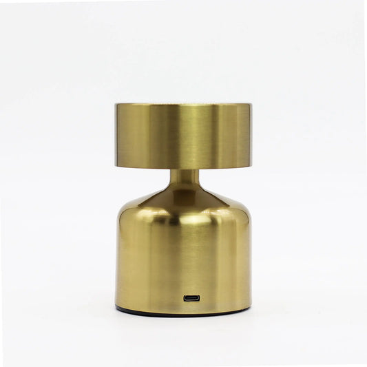 Lámpara táctil de mesa en bronce con forma de champiñón, diseño moderno, acabado metálico y puerto de carga USB-C.
