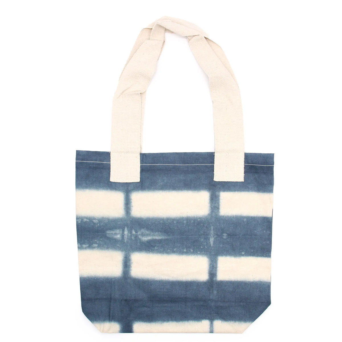 Bolsa de algodón natural con diseño tie-dye de rectángulos grises y asas largas de color crudo, sobre fondo blanco.