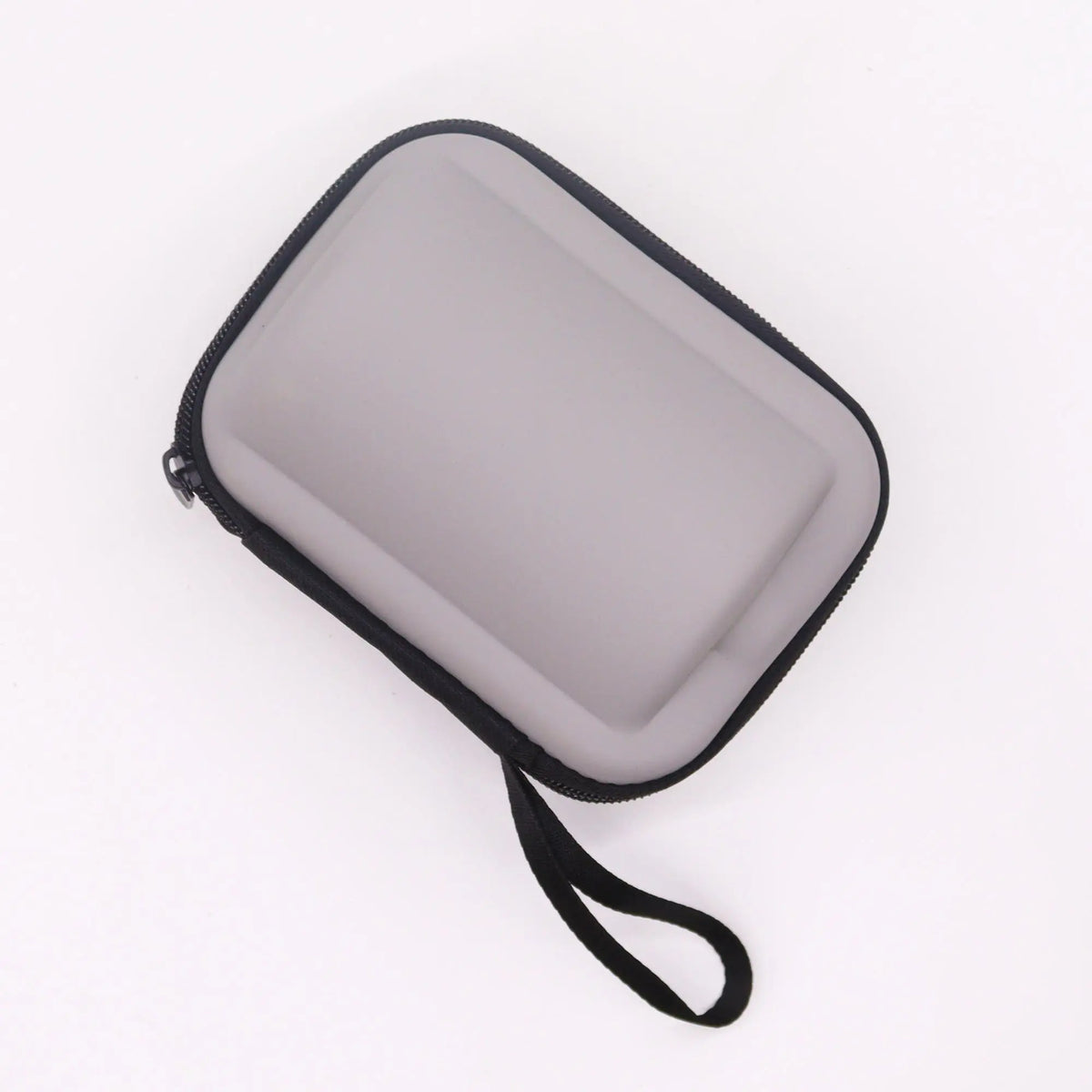Estuche de viaje rígido y gris, rectangular, con cremallera negra y correa, ideal para kit de té portátil.