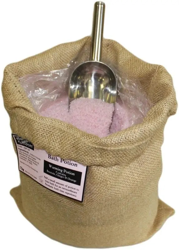 Saco de arpillera con 7kg de sales de baño rosadas, etiqueta Ancient Wisdom y pala metálica para servir.