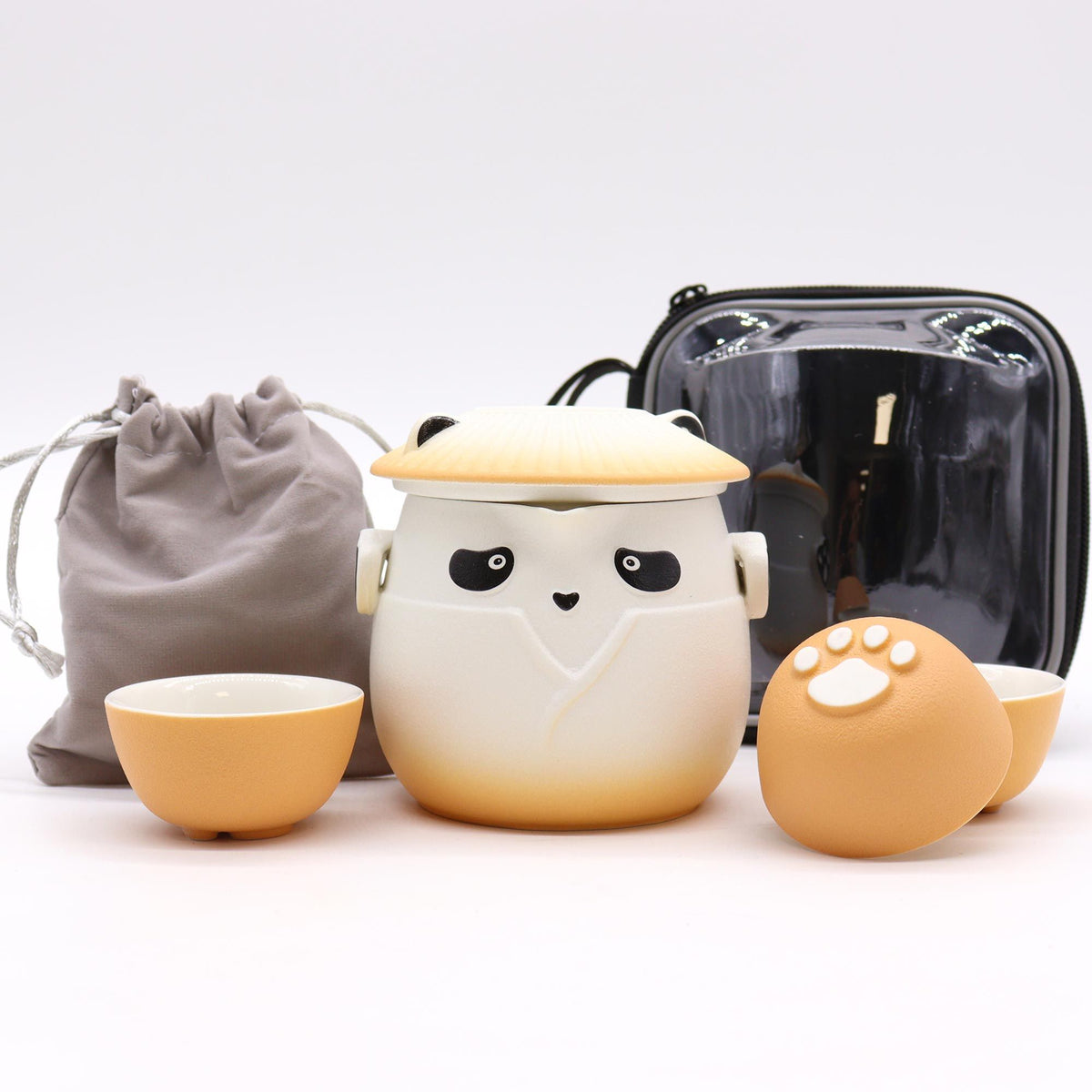 Juego de té cerámico con diseño de panda, incluye tetera con tapa y tres tazas naranja con huella de pata y estuche.