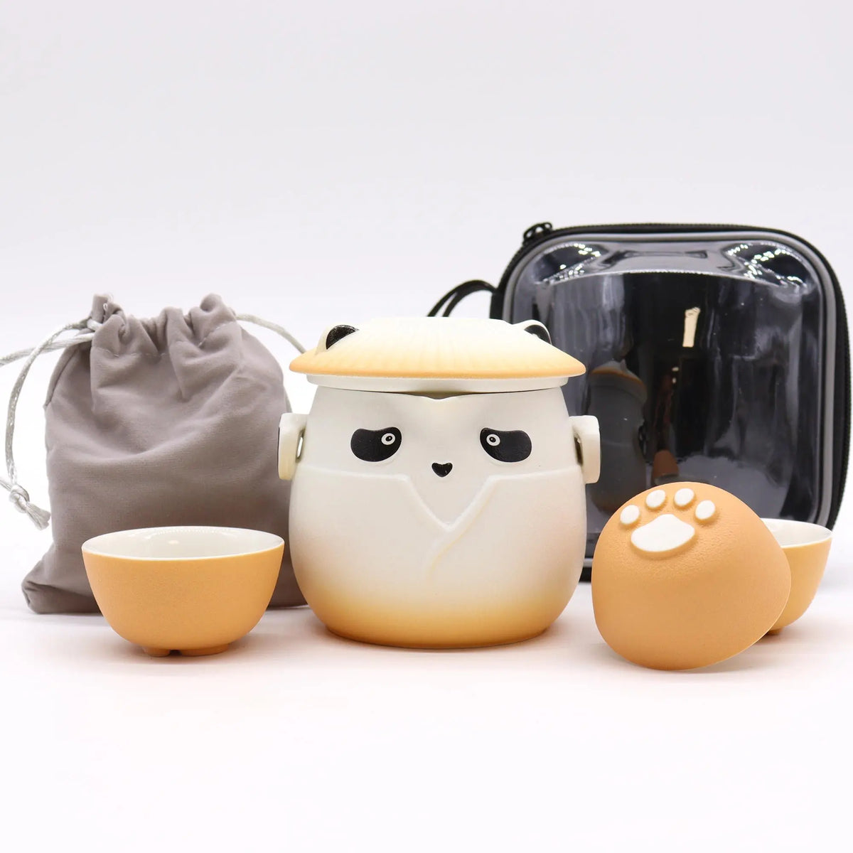 Juego de té cerámico con diseño de panda, incluye tetera con tapa y tres tazas naranja con huella de pata y estuche.