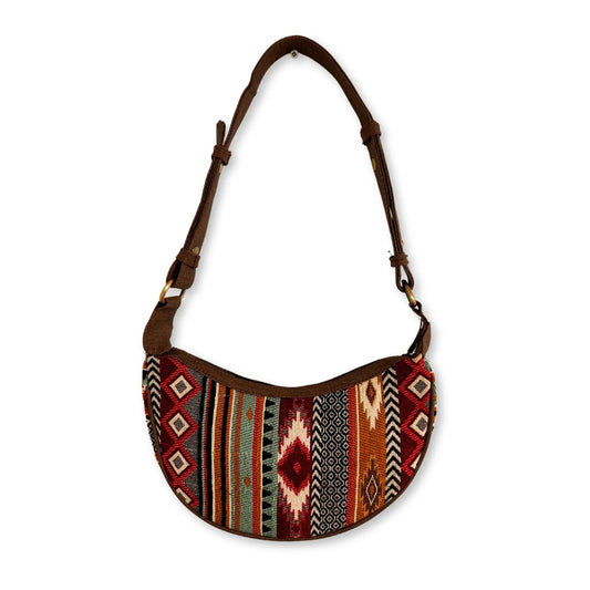 Bolso hobo semicircular de jacquard con patrones geométricos en tonos marrones y correa de hombro ajustable.