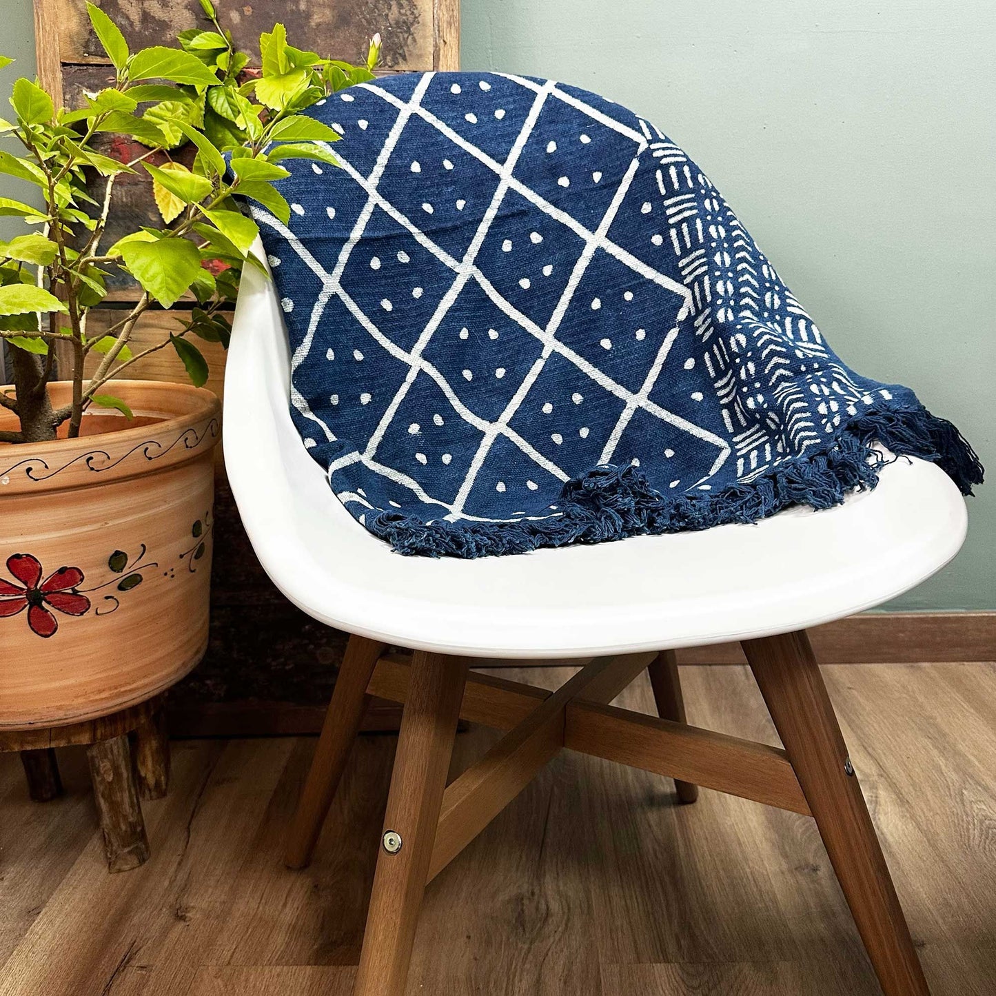 Manta azul marino de algodón con diseño geométrico blanco y flecos, perfecta para decorar y abrigar.