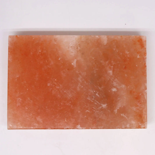 Plancha rectangular de sal del Himalaya, de color rosado translúcido con textura natural, sobre fondo blanco.