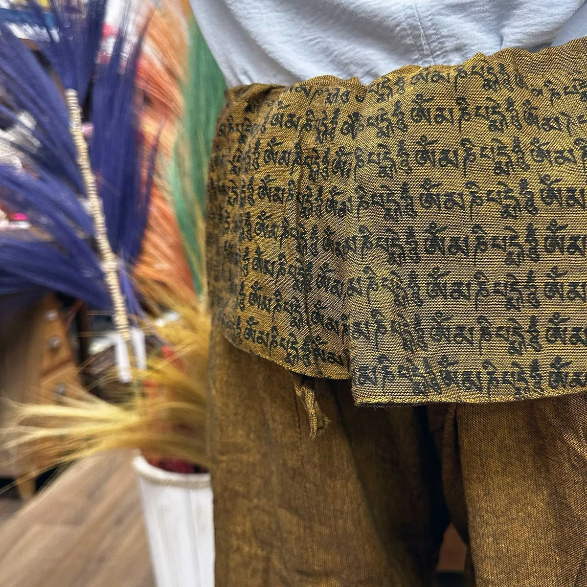 Pantalones de yoga tipo pescador en color naranja mostaza con estampado de mantras en la cintura, estilo bohemio y ligero
