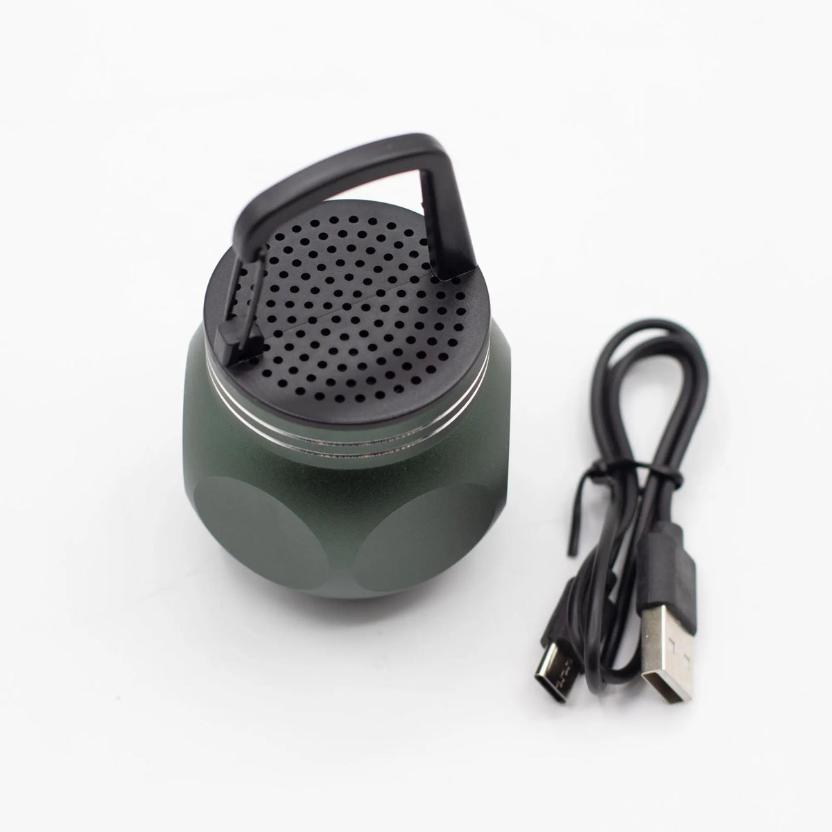 Altavoz Bluetooth mini color verde oliva, forma esférica, gancho de plástico negro y cable de carga USB incluido.