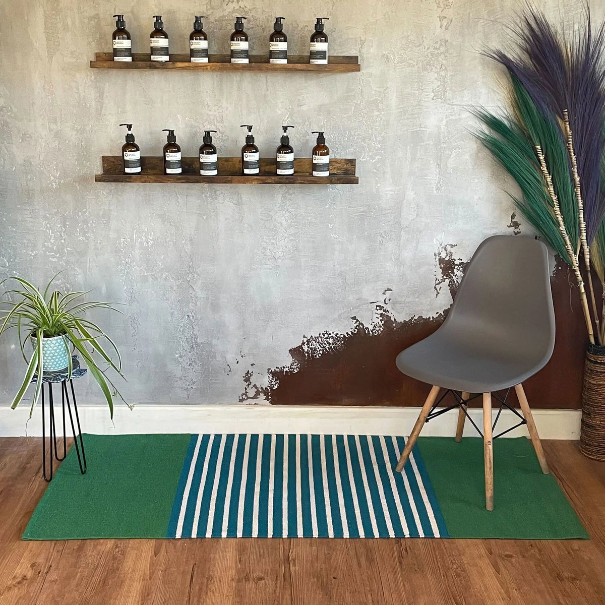 Alfombra rectangular de algodón, diseño artesanal con franjas azules y verdes, estilo moderno en interior decorado.