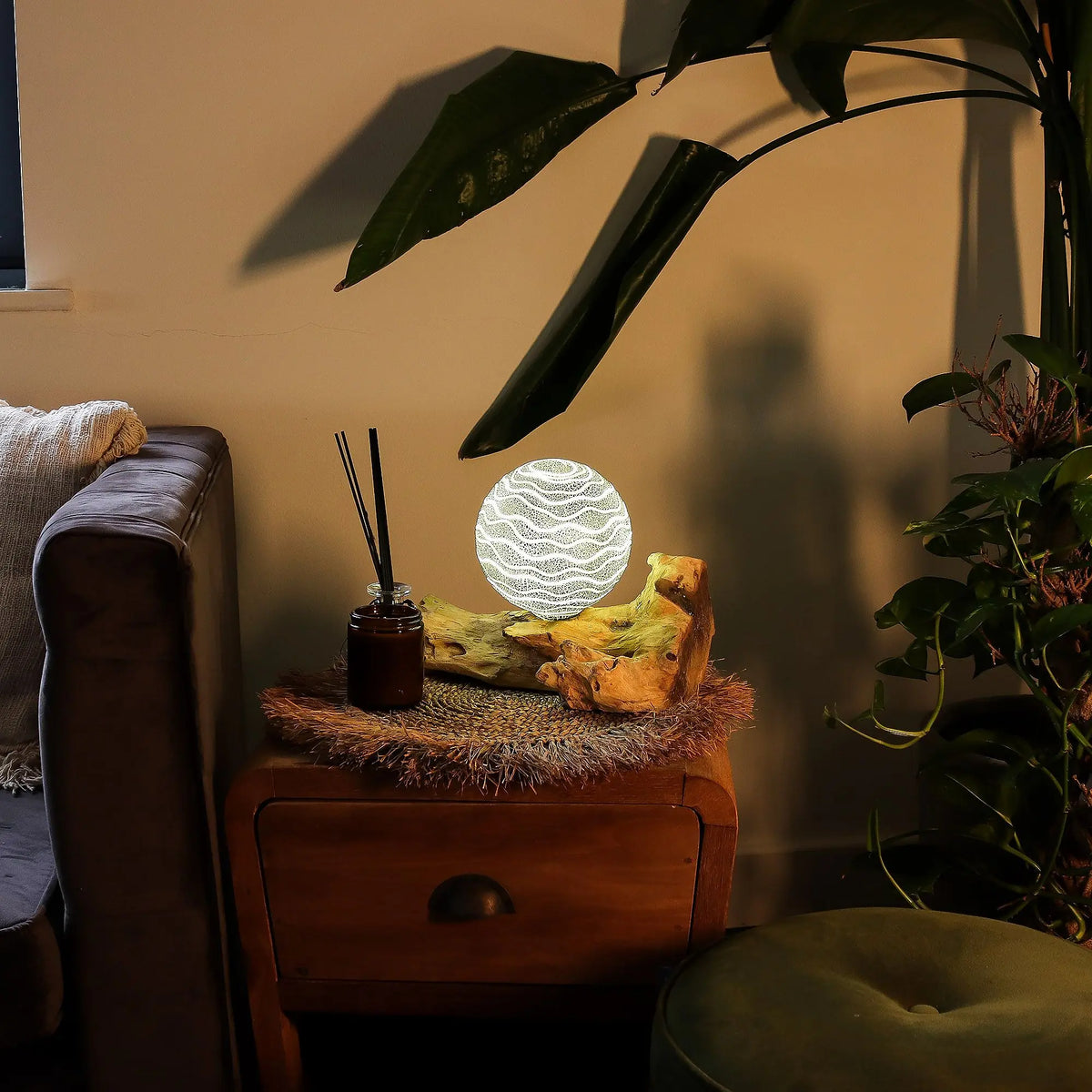 Lámpara de mesa esférica con rayas luminosas sobre una base de madera natural, colocada en una mesita de noche.