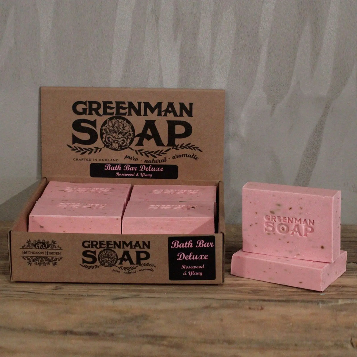 Caja de cartón con jabones Greenman de color rosa, con textura y logo grabado, aroma a palo de rosa e ylang.