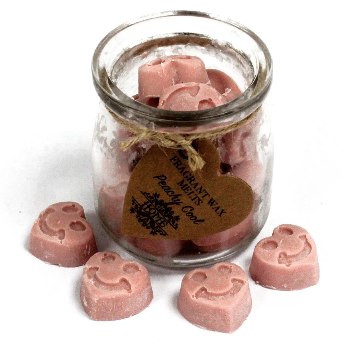 Frasco de vidrio con pastillas de cera de soja rosa en forma de carita feliz y etiqueta en forma de corazón.
