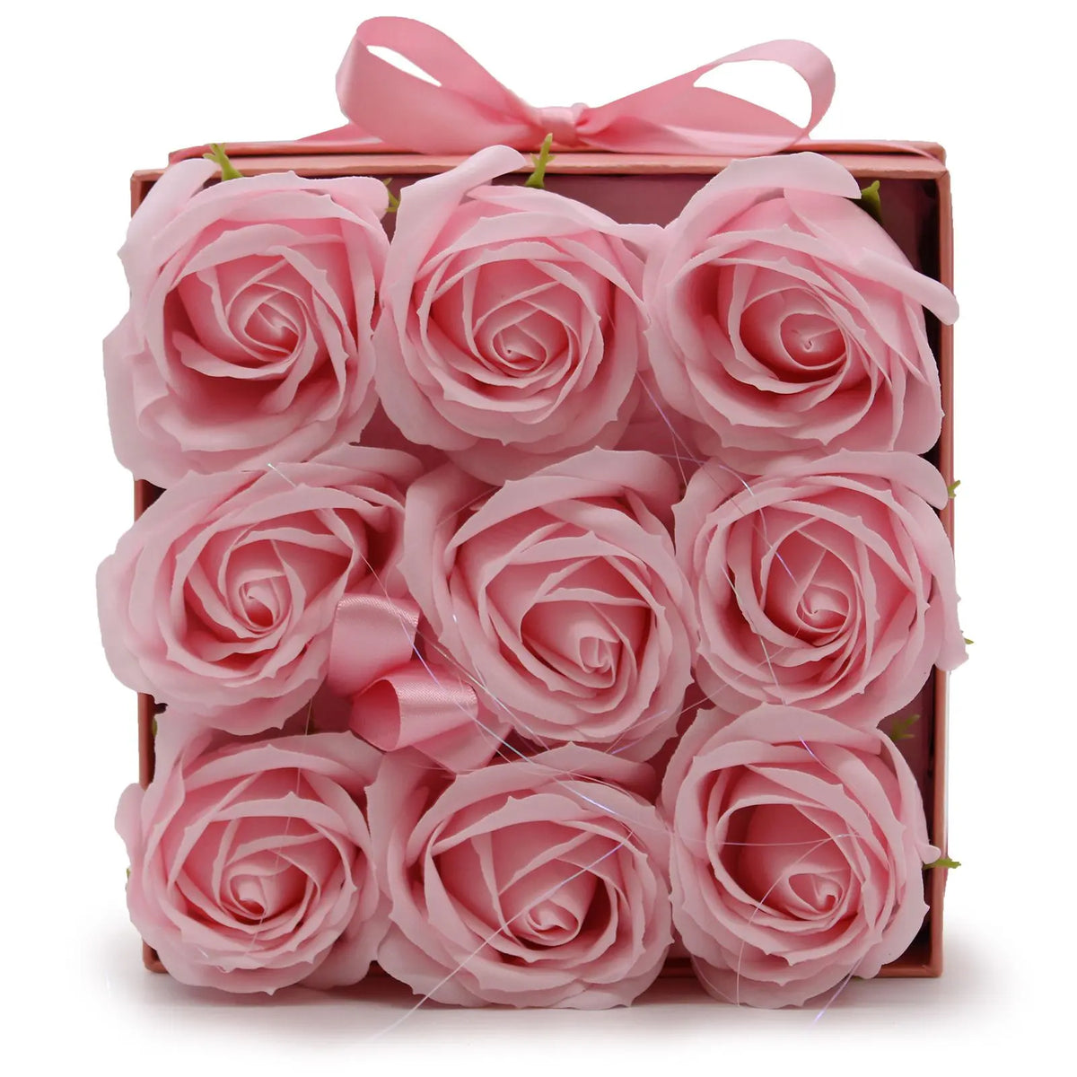 Caja cuadrada rosa con nueve rosas de jabón realistas dispuestas en cuadrícula y decorada con un lazo de satén.