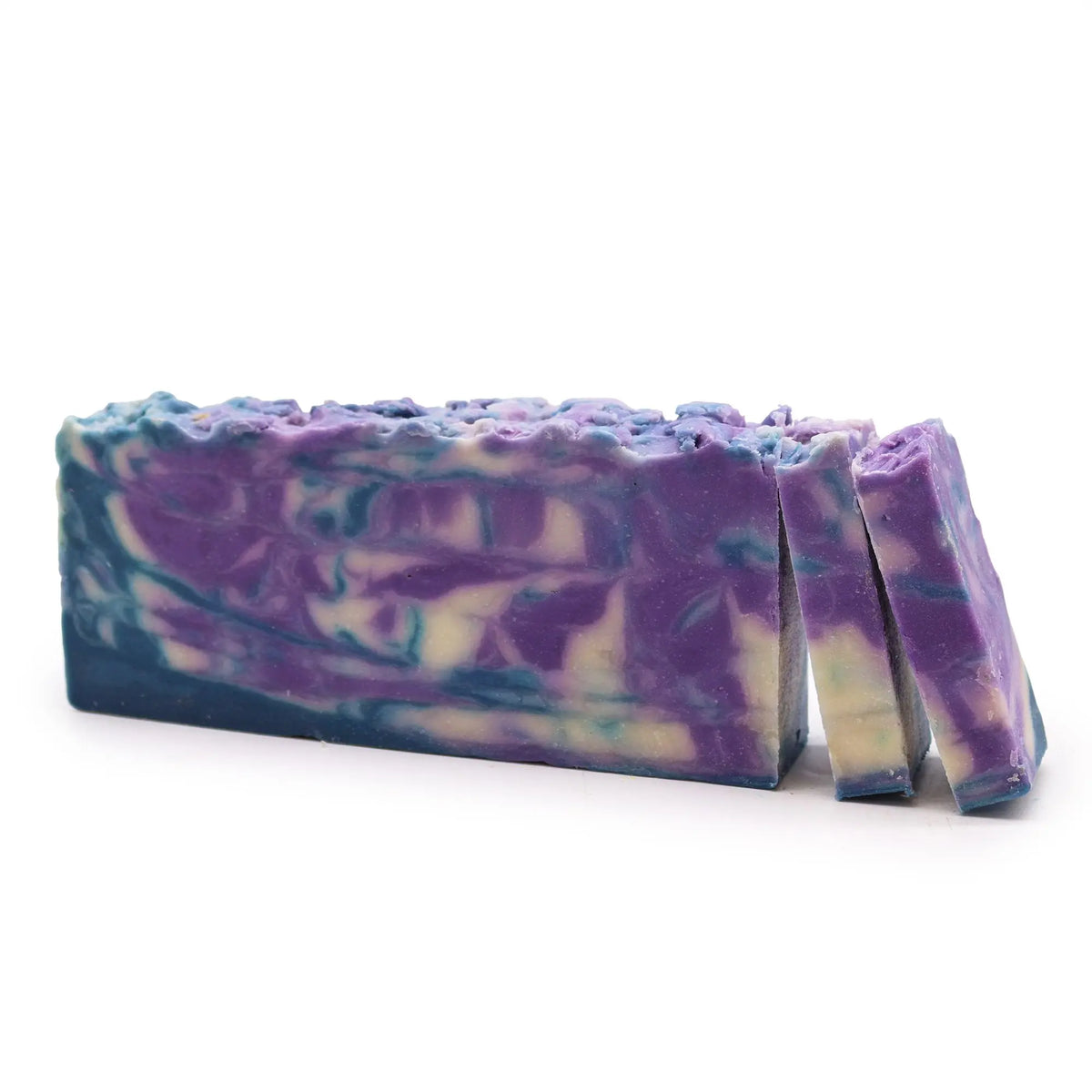 Barra de jabón artesanal de 1.25kg con remolinos en tonos violeta, azul y blanco sobre fondo blanco.