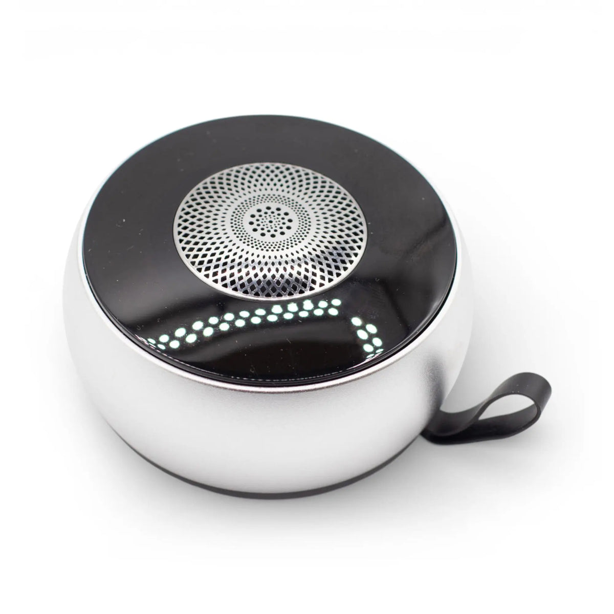 Altavoz Bluetooth redondo, plateado, con rejilla superior de patrón mandala y luz LED sobre fondo negro. Marca: Ancient Wisdom.