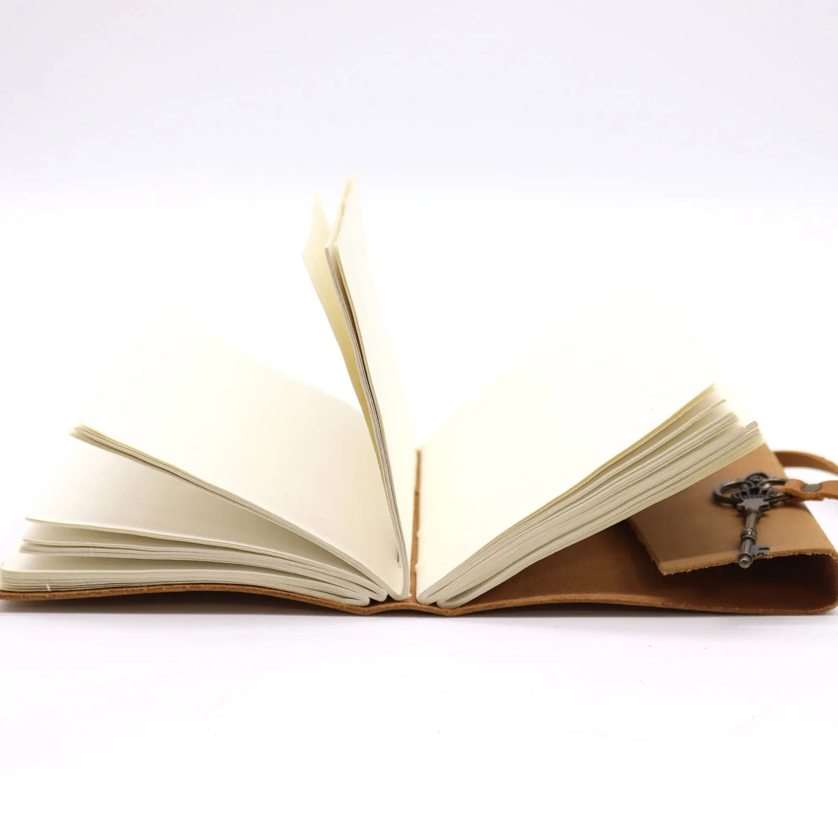 Cuaderno de cuero marrón con llavero, hojas en blanco, estilo vintage para notas y diario personal.