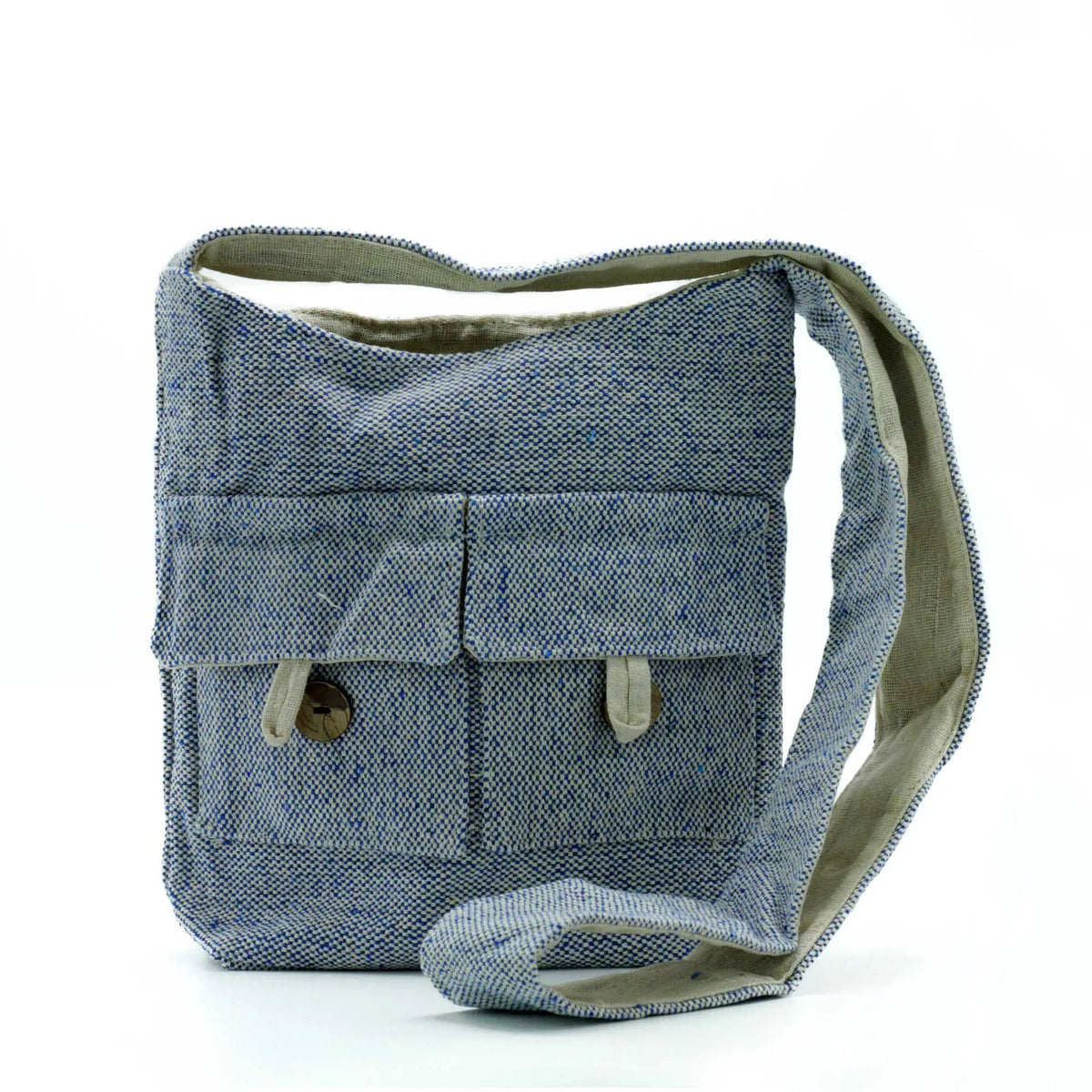 Bolso bandolera de tela azul denim con textura, dos bolsillos frontales con botones y asa larga en tono natural.