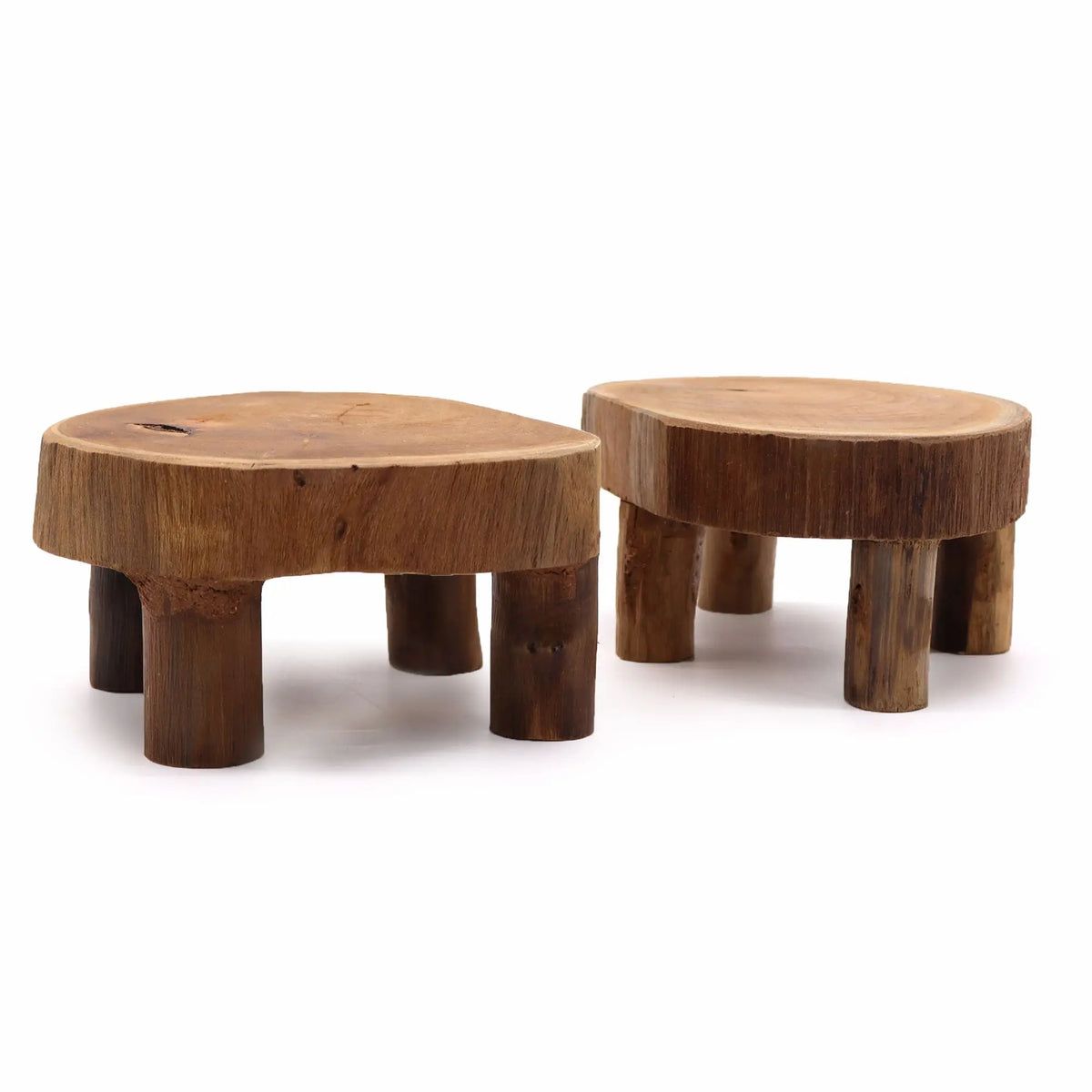Dos mesas bajas de madera de teca natural con diseño rústico y patas cilíndricas sobre fondo blanco