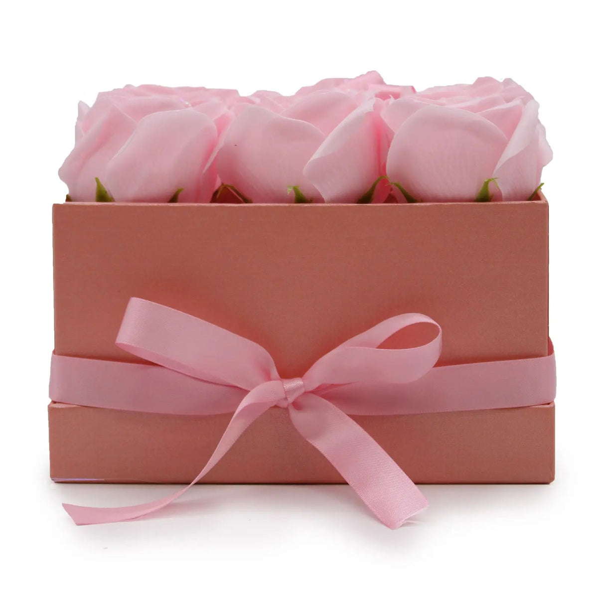 Caja cuadrada rosa con nueve rosas de jabón y un lazo decorativo de satén, sobre fondo blanco.