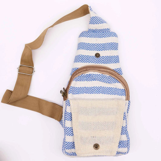 Bolso bandolera de algodón con patrón de rayas azules y blancas, bolsillo frontal con cierre y correa ajustable marrón.