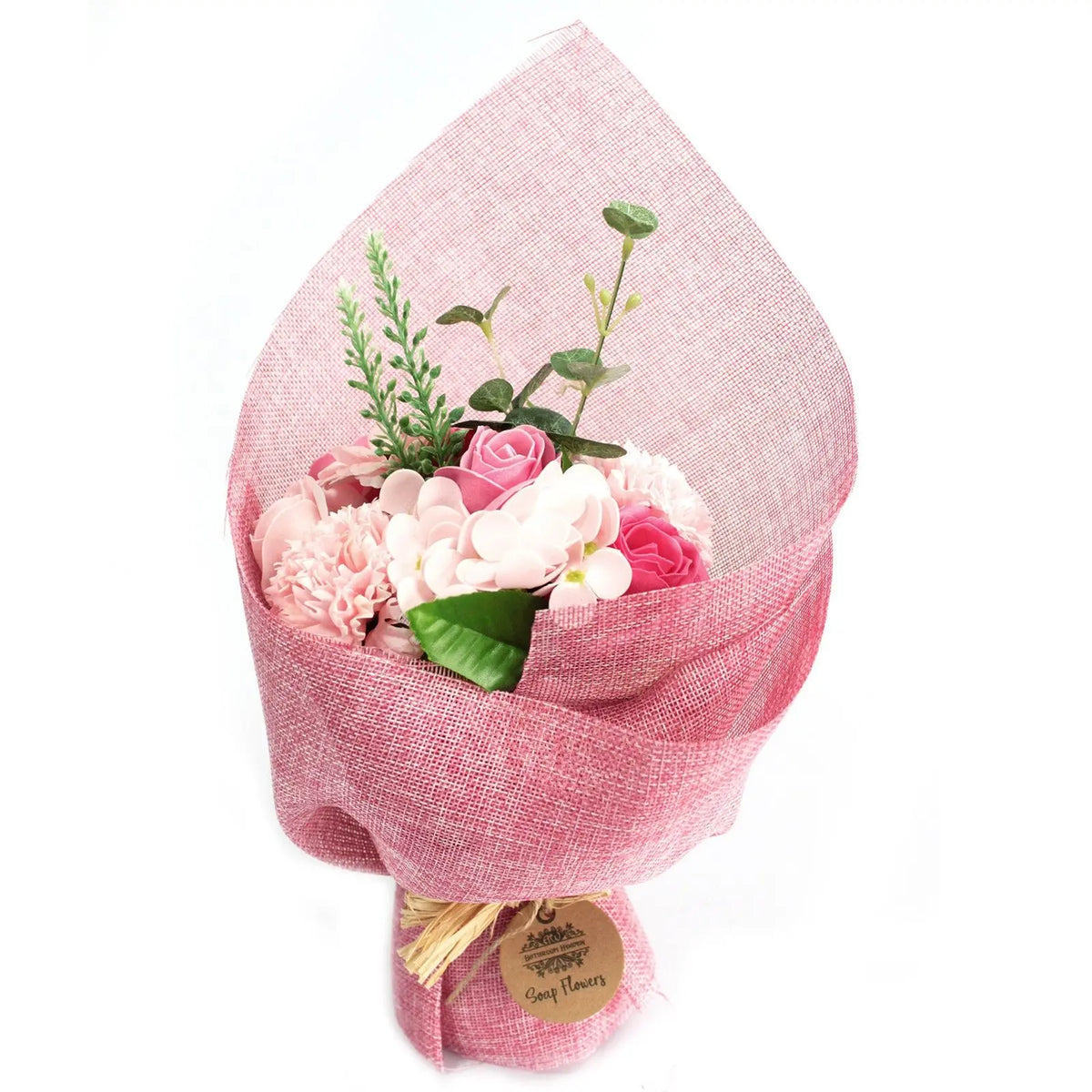 Ramo de flores de jabón en tonos rosa, envuelto en papel decorativo rústico con una etiqueta de cartón.